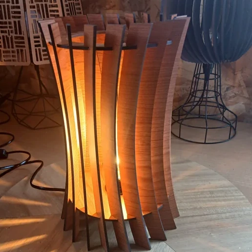 Lampe décorative en bois découpé au laser, allumée dans l'atelier LASERAM
